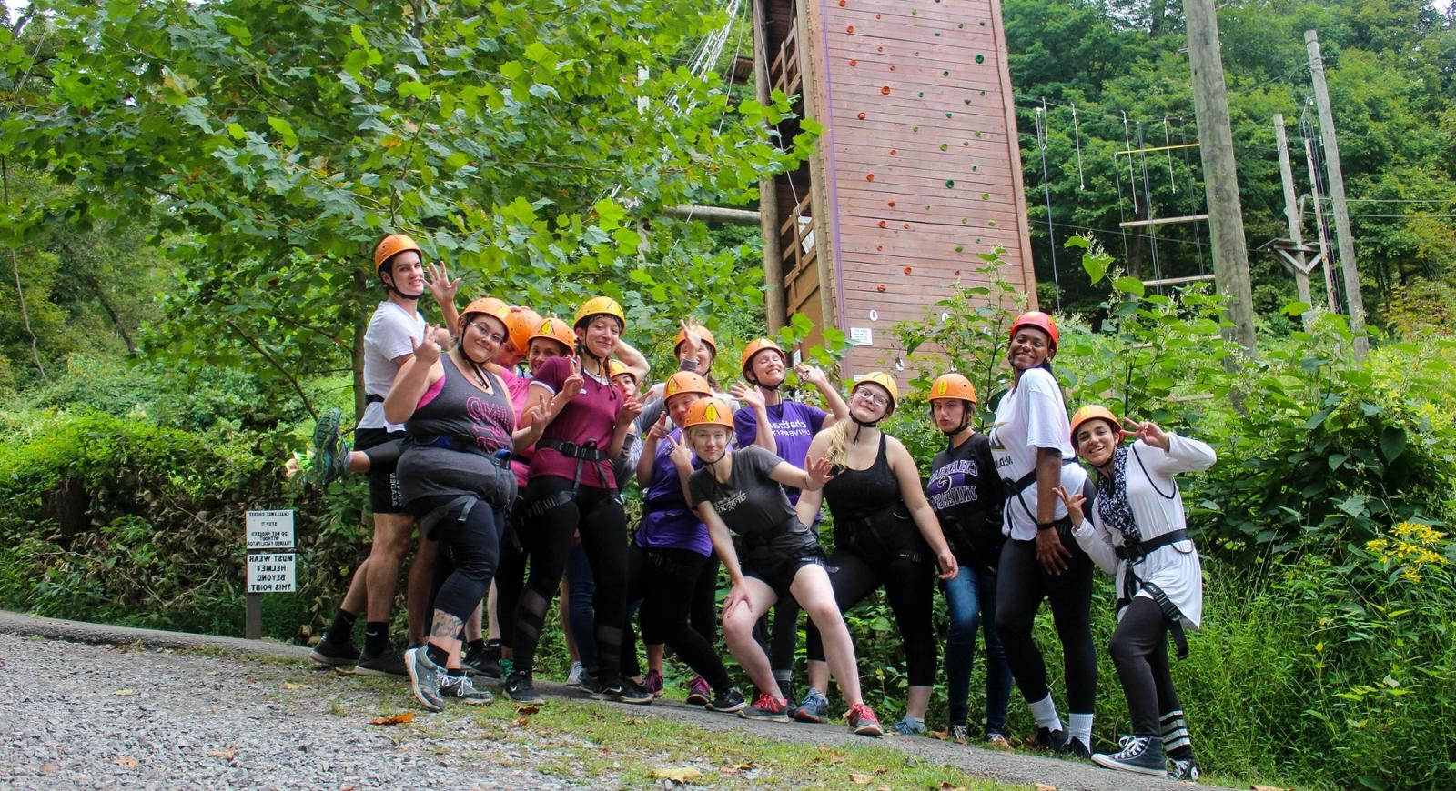 Photo of a group of Chatham University students at an obstacle course in the forest